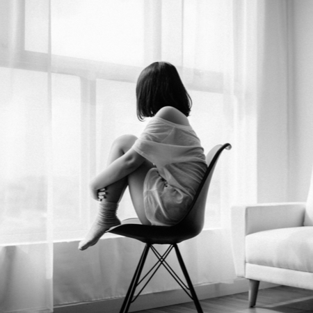 woman sitting on chair looking out window